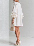 Vestido blanco de lino con botones florales y mangas con flores voluminosas, vista trasera