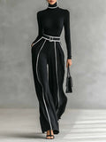 Conjunto negro con cuello alto, cinturón y pantalón de pierna ancha con franja blanca