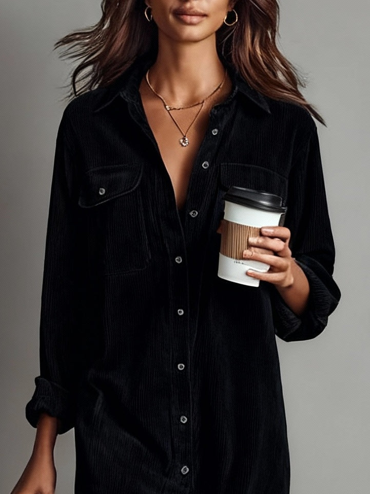 Vestido camisero midi negro de pana, botones frontales y bolsillos en el pecho.