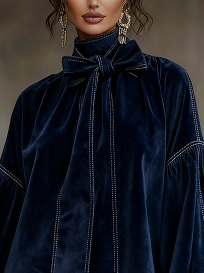 Vestido azul oscuro con cuello alto anudado y pespuntes a contraste en el frente