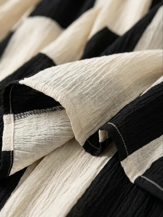 Detalle del vestido maxi: tela de algodón negra y blanca con costuras y pliegues