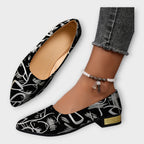 Bailarinas Amélie negras con estampado dorado y tacón ancho bajo; pulsera de tobillo