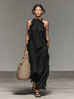 Vestido largo de lino negro con volantes en el escote, espalda descubierta y sin mangas.