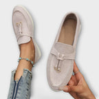 Mocasines Bianca beige de gamuza con herrajes metálicos y cordón delantero.