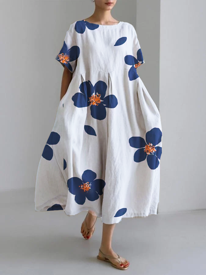 Vestido fluido floreal blanco con flores grandes azules y centros naranjas, manga corta holgada