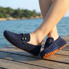 Mocasines de cuero perforado azul marino con costuras visibles y suela naranja