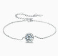 Pulsera tipo solitario de plata con dije circular y piedra transparente engastada.