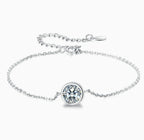 Pulsera tipo solitario de plata con dije circular y piedra transparente engastada.