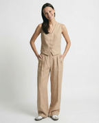 Conjunto de lino beige con chaleco abotonado y pantalón ancho de tiro alto.