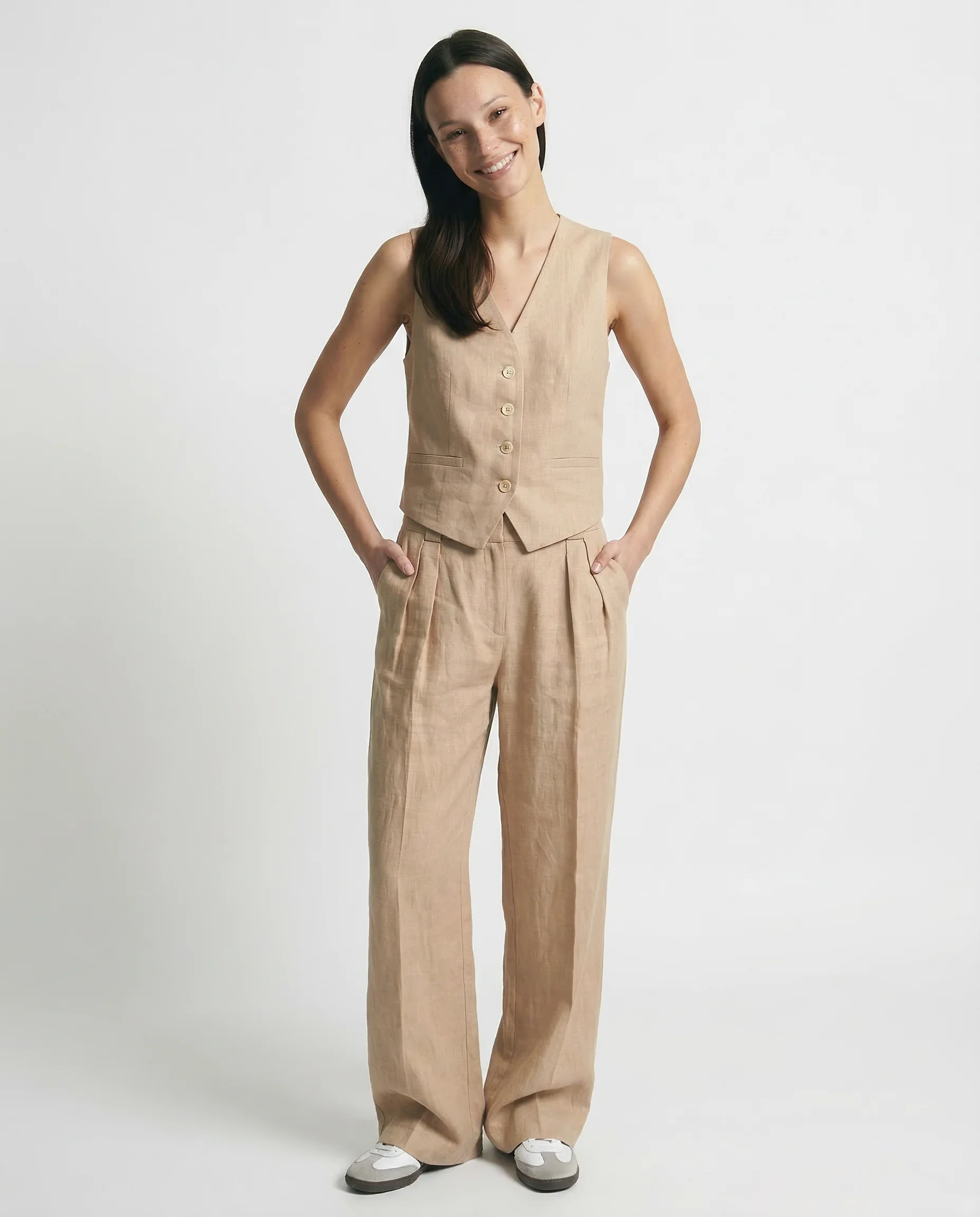 Conjunto de lino beige con chaleco abotonado y pantalón ancho de tiro alto.