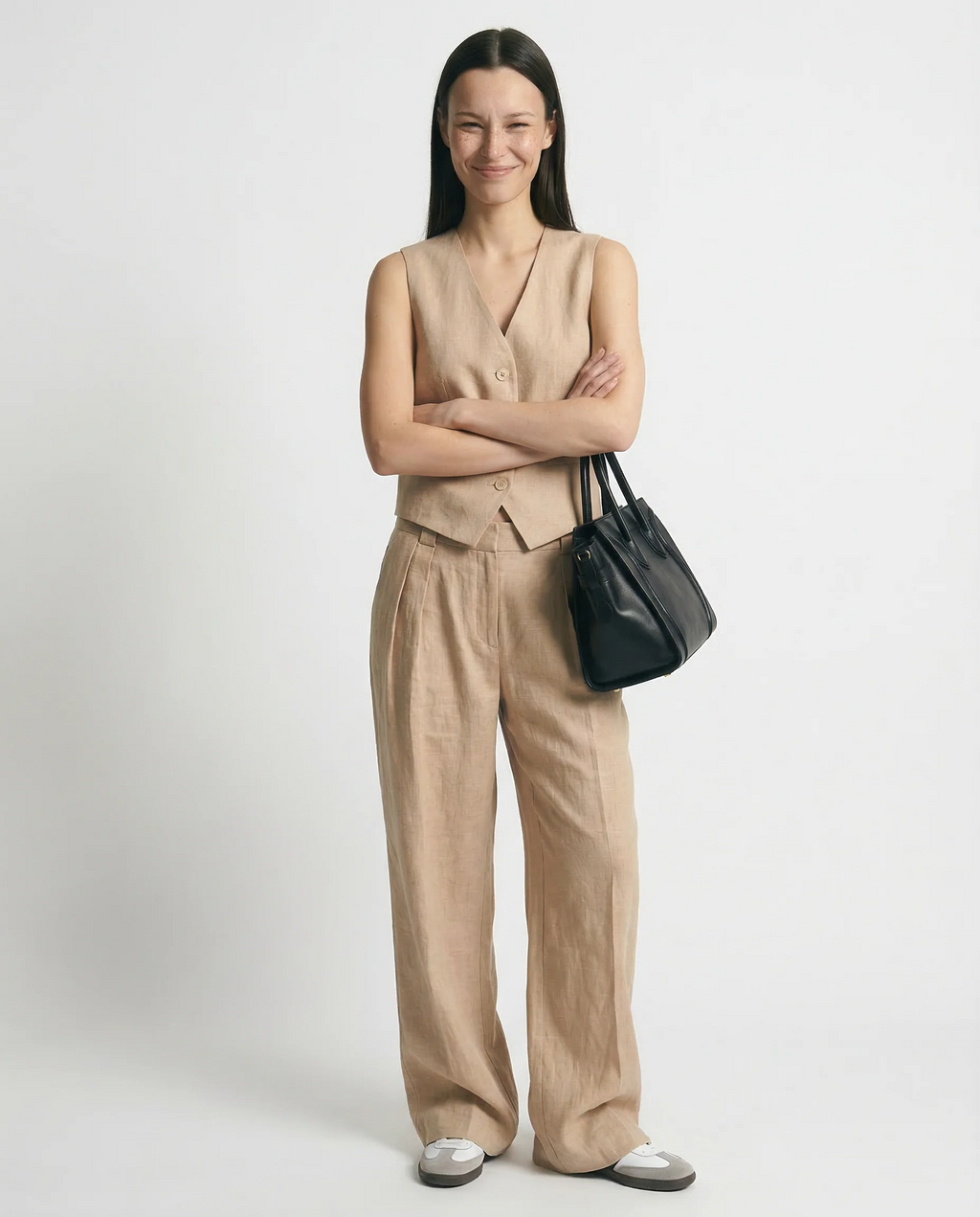 Conjunto de lino beige con chaleco abotonado y pantalón ancho de costuras visibles.