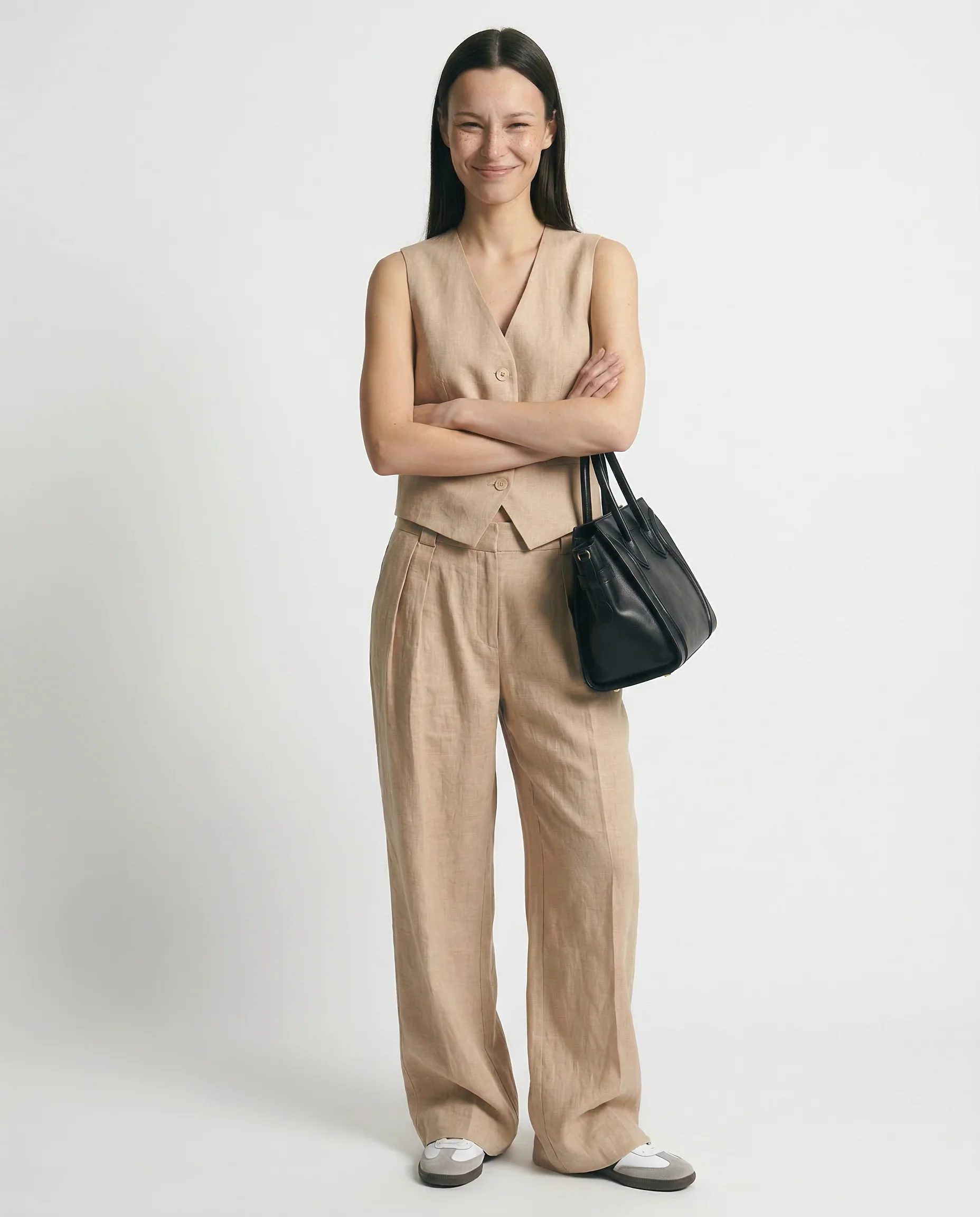 Conjunto de lino beige con chaleco abotonado y pantalón ancho de costuras visibles.