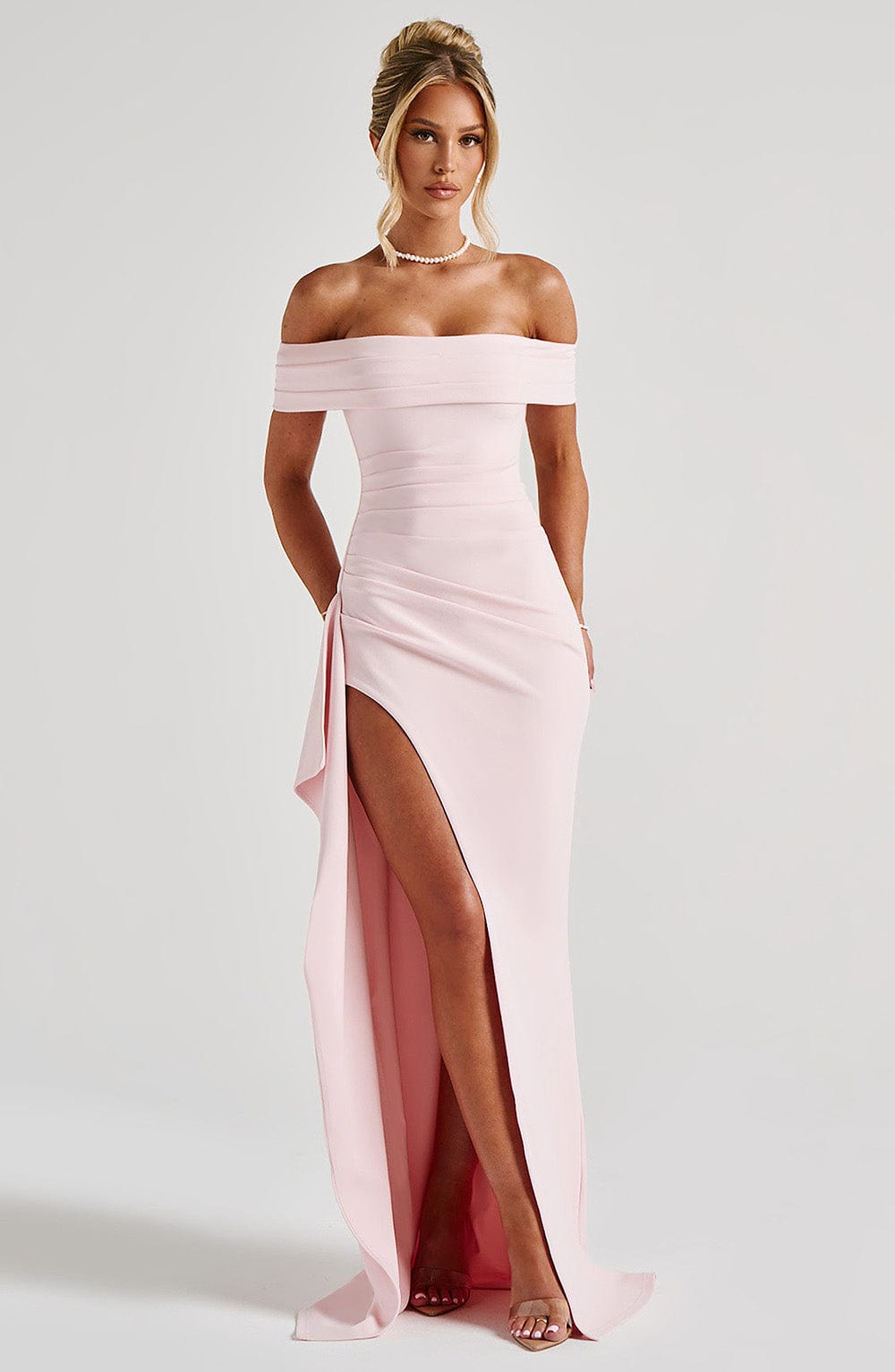 Vestido largo rosa con hombros descubiertos y abertura lateral con cascada de tela