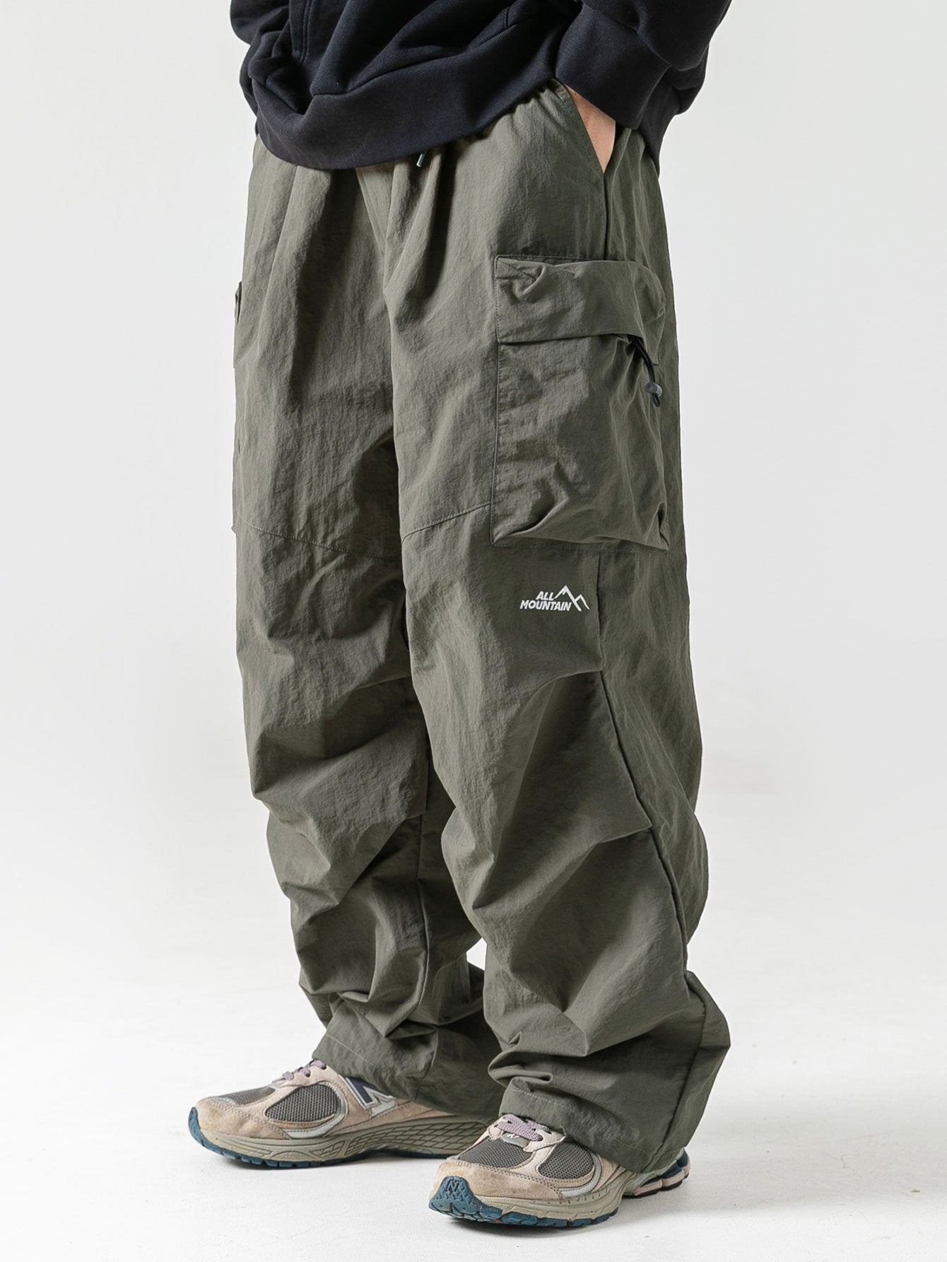 Pantalón paracaídas verde oscuro con bolsillos tipo cargo y etiqueta pequeña
