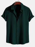 Camisa Milano de manga corta verde oscuro, cuello camisero y botones frontales.