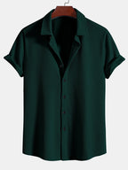 Camisa Milano de manga corta verde oscuro, cuello camisero y botones frontales.