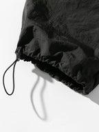 Pantalón parachute hidrófugo negro con bajo elástico y cordón ajustable