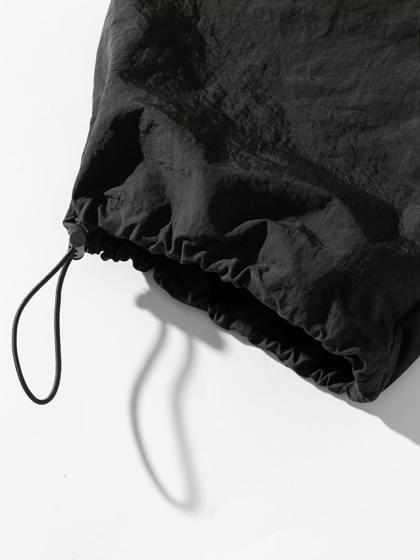 Pantalón parachute hidrófugo negro con bajo elástico y cordón ajustable
