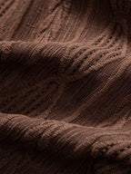 Camisa café: primer plano del tejido con relieve y tramas entrelazadas.