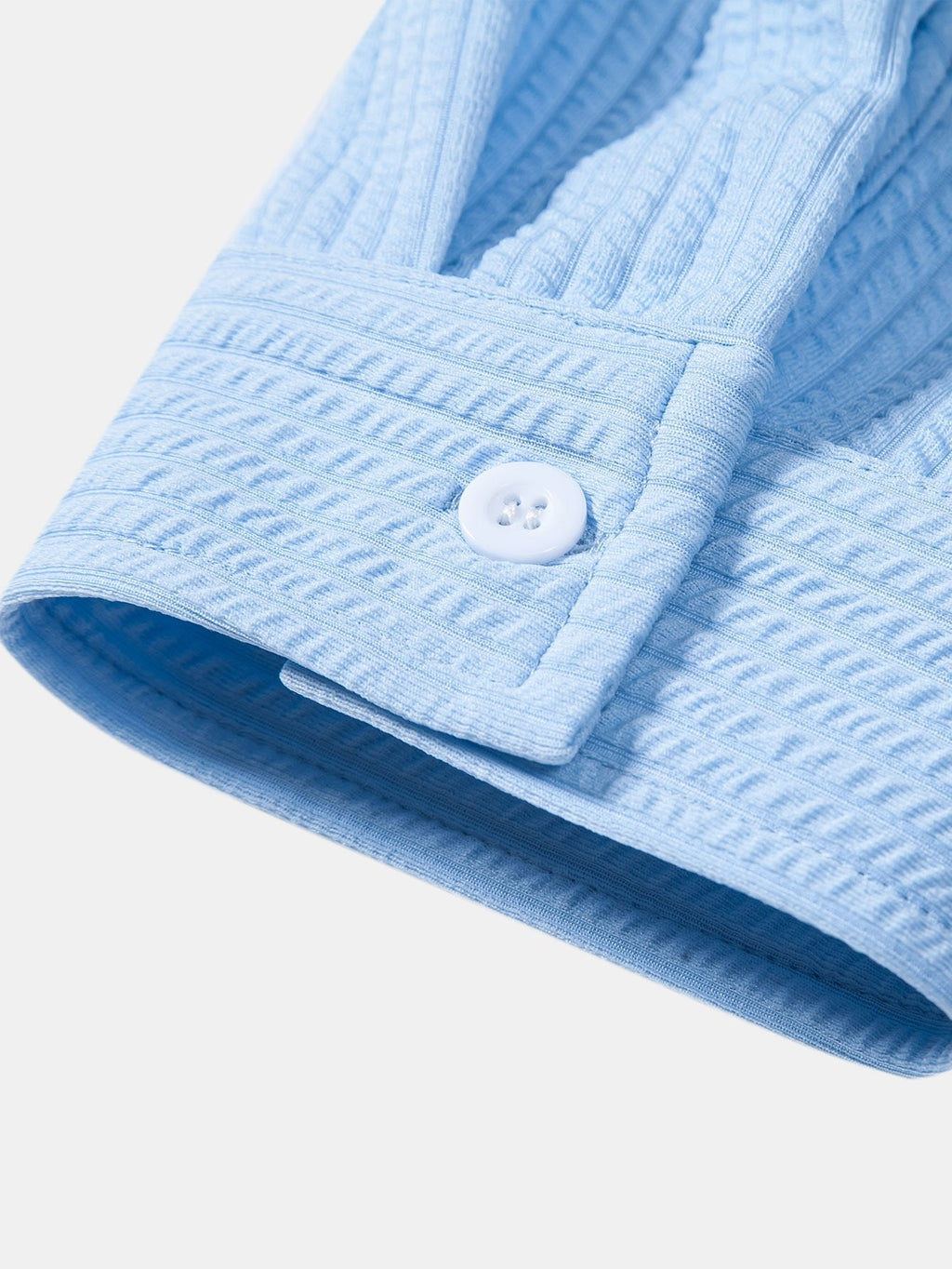 Manga y puño de camisa azul acanalada con botón y doble abertura