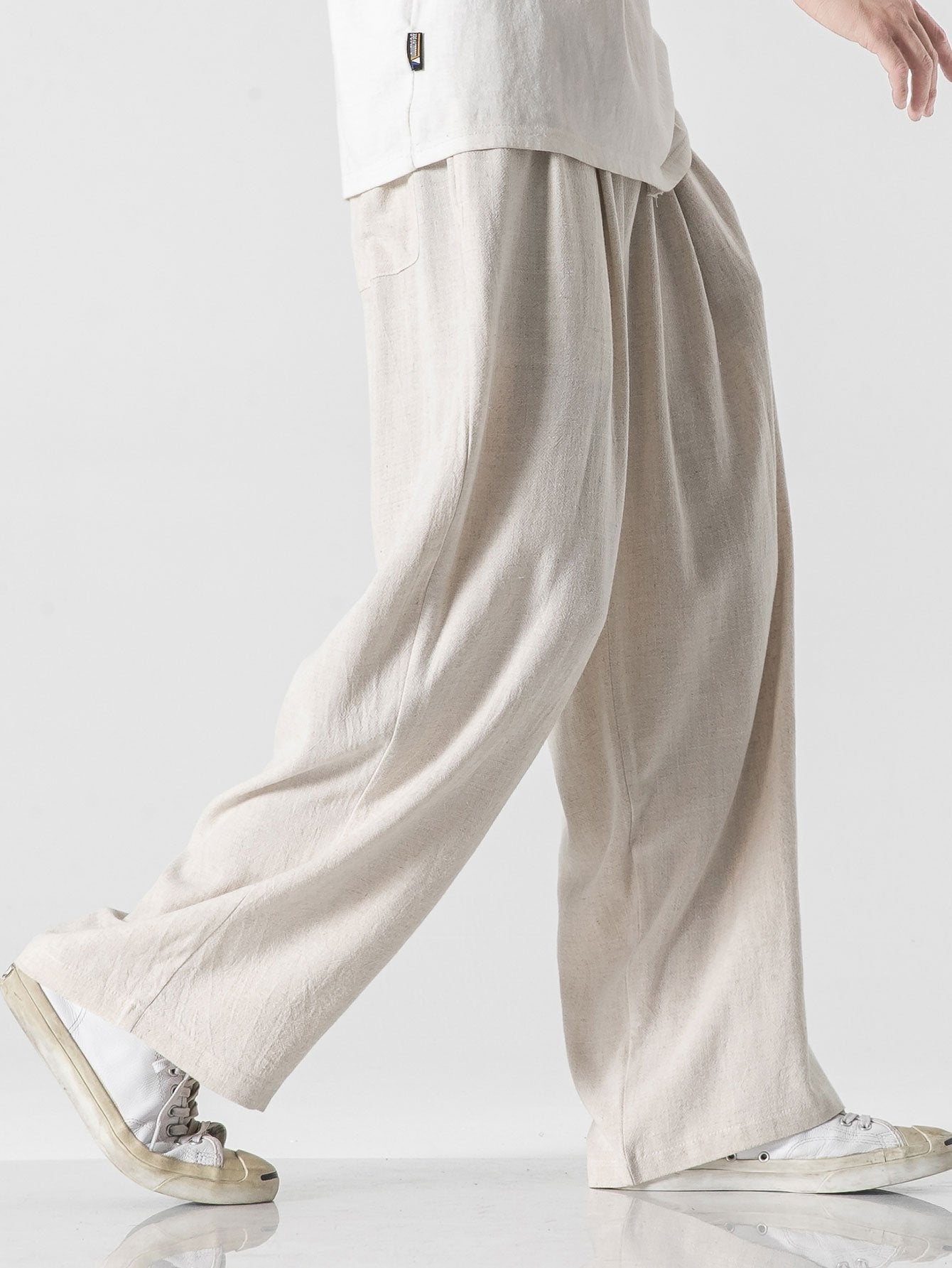 Pantalón wide leg de lino y algodón beige claro, dobladillo amplio y tela con textura.