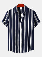Camisa de botones de rayas marino y blancas, manga corta, cuello tipo camisa.