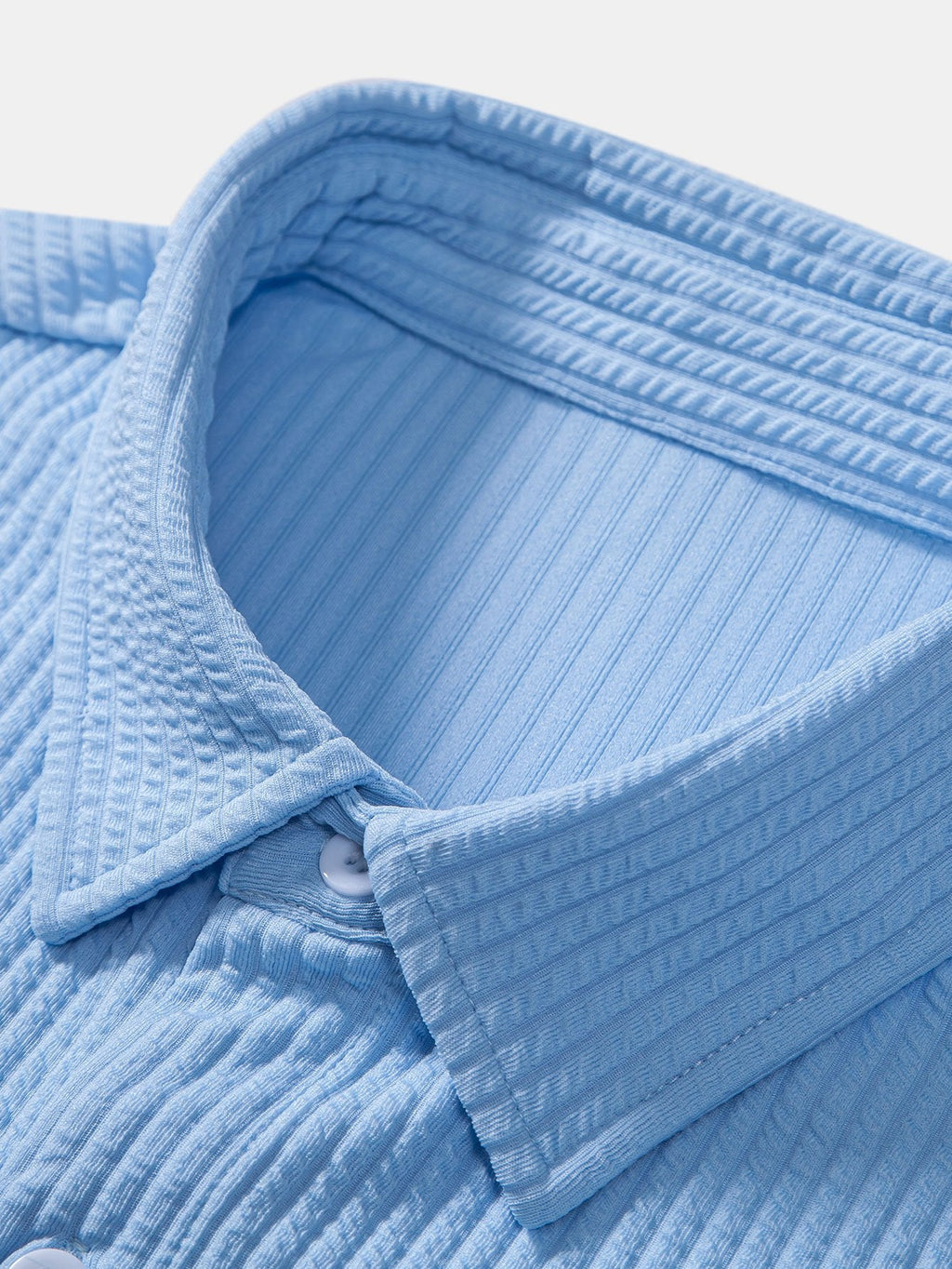 Detalle de camisa Milano azul claro: tejido texturizado y costuras del cuello.