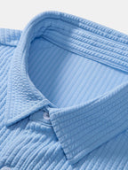 Detalle de camisa Milano azul claro: tejido texturizado y costuras del cuello.