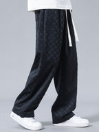 Pantalón recto oscuro con patrón damero, bolsillo lateral y dobladillo amplio.