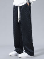 Pantalón recto oscuro con patrón damero, cordón blanco y corte holgado.