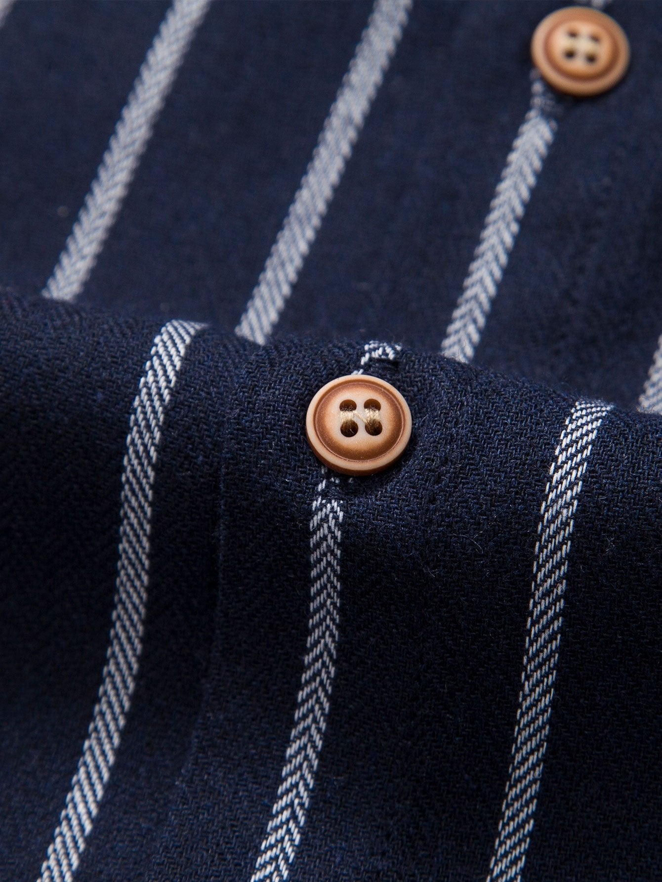 Camisa azul marino de rayas con botones marrones en la tapeta.