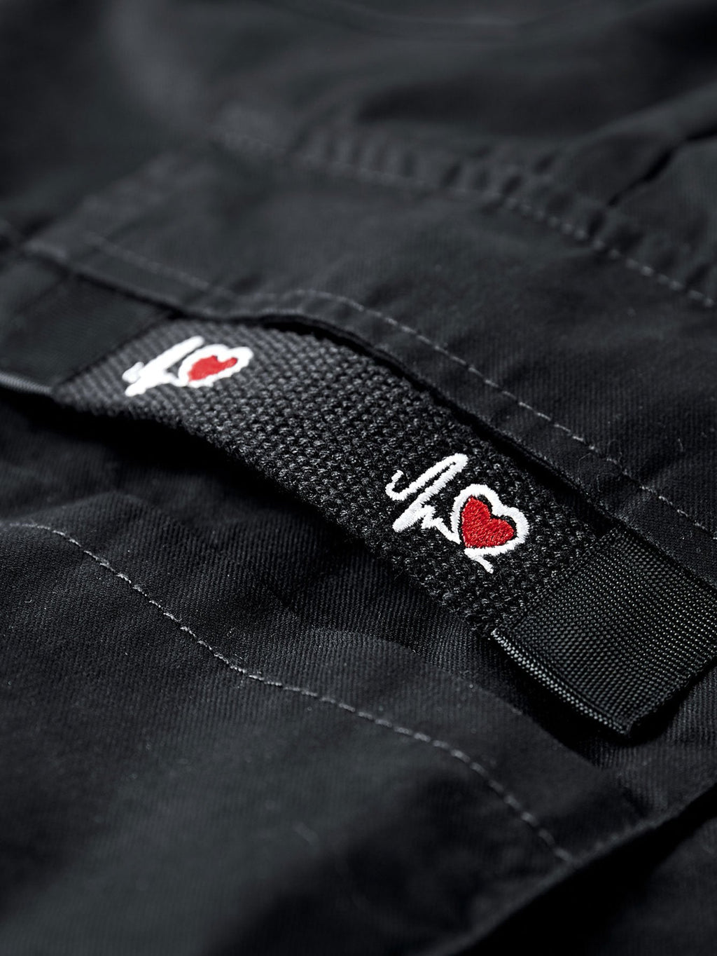 Pantalón corto negro con parche de marca en la cintura y costuras visibles