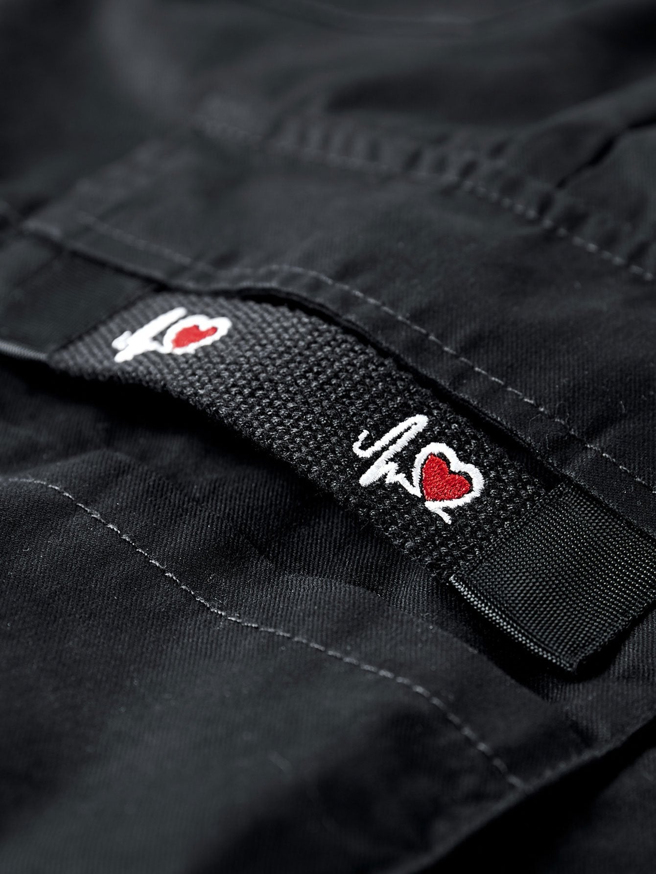 Pantalón corto negro con parche de marca en la cintura y costuras visibles