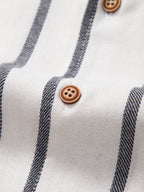 Detalle de camisa cubana: botones marrón y rayas verticales blanco y gris