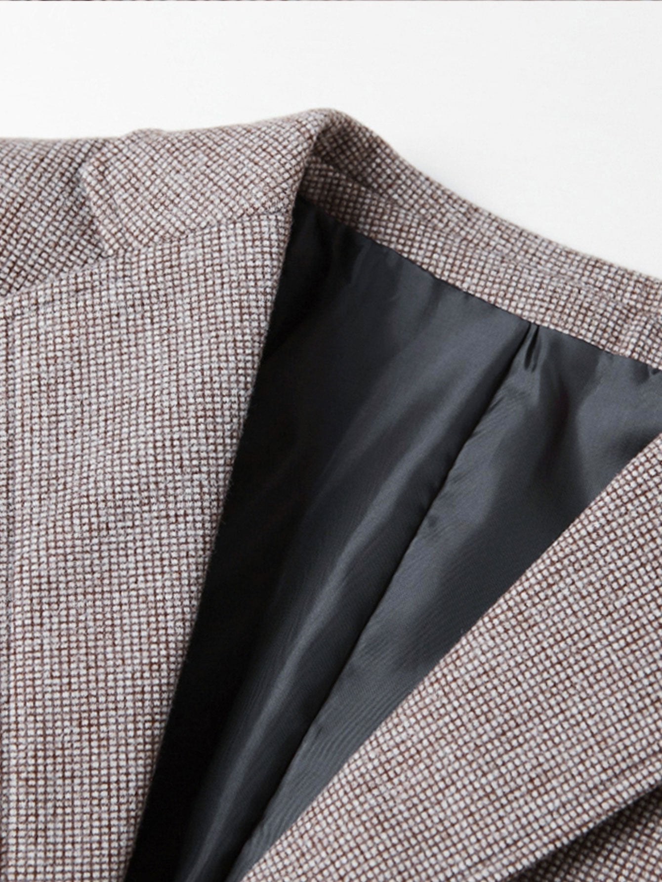 Detalle del cuello y solapa interior de blazer de cuadro príncipe gris con forro negro
