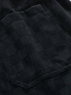 Detalle del tejido del pantalón con relieve cuadriculado en negro
