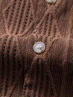 Camisa café: vista frontal con botones redondos y solapa, textura acanalada.