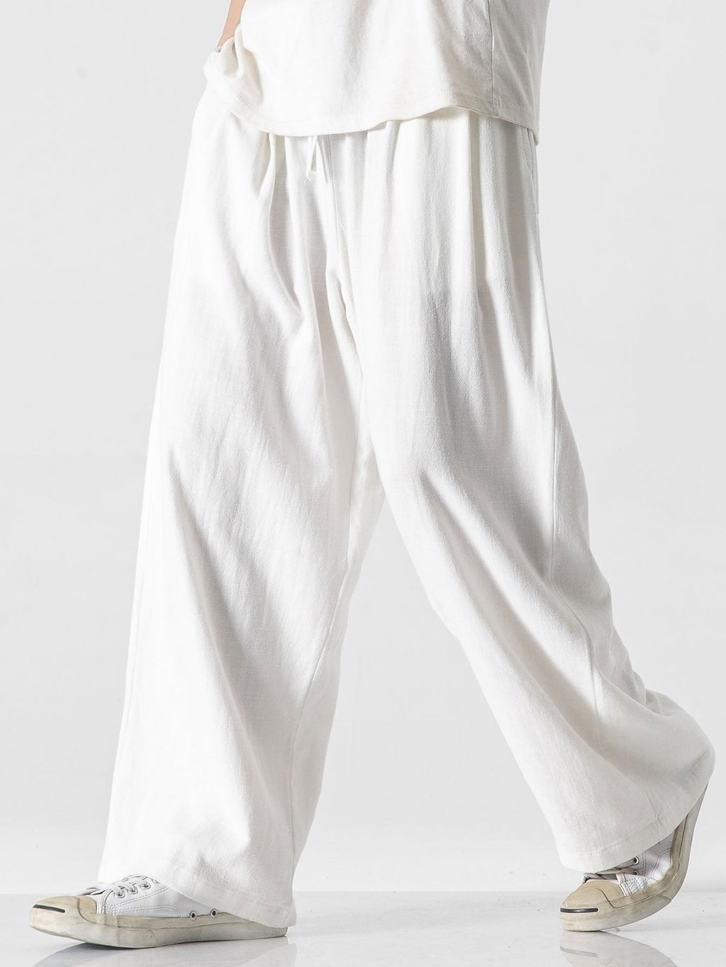 Pantalón wide leg de lino y algodón blanco roto, caída suelta y frunces en la cintura.