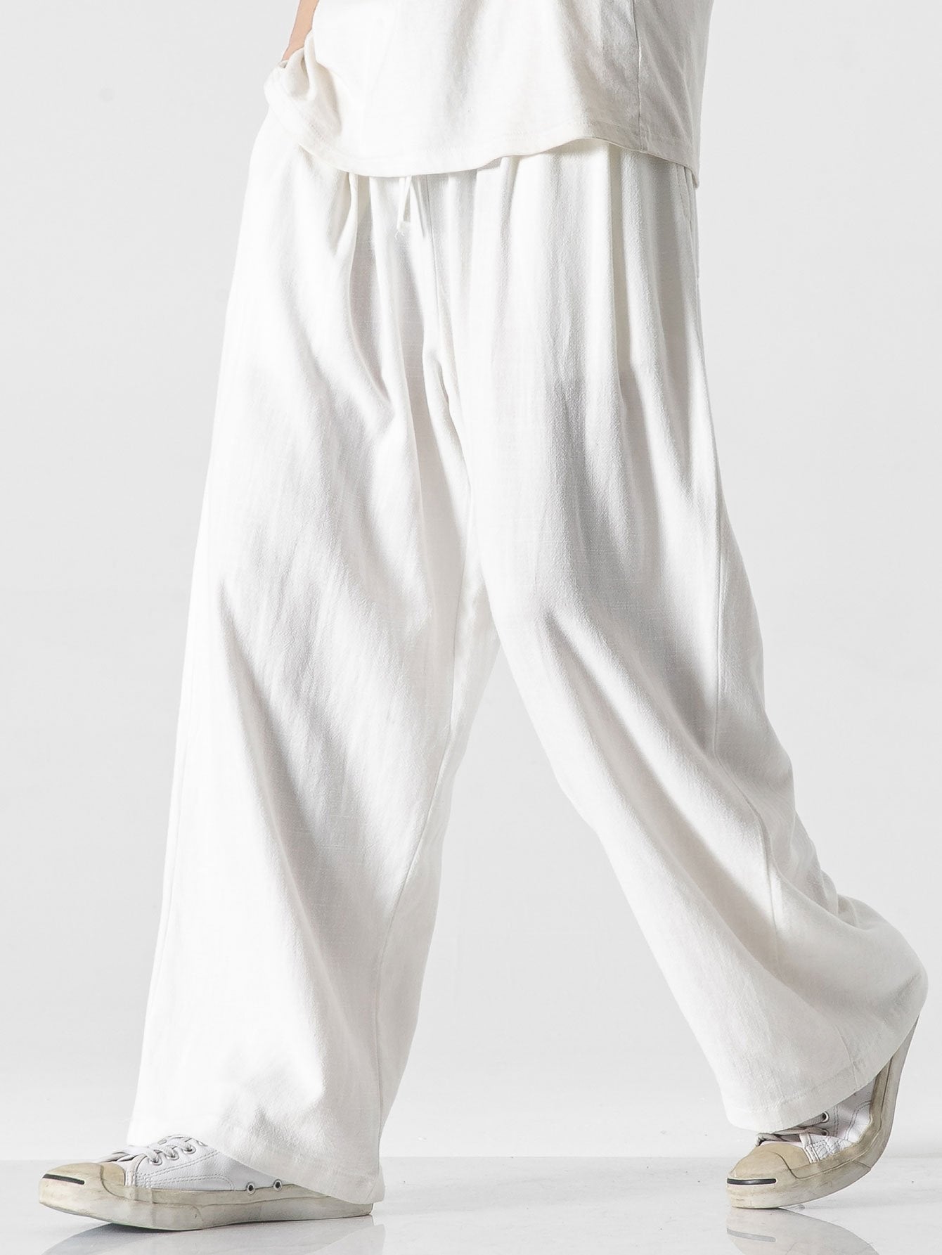 Pantalón wide leg de lino y algodón blanco roto, caída suelta y frunces en la cintura.