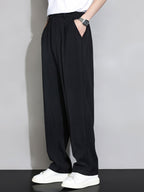 Pantalón recto relajado negro con pliegues en la cintura y pernera amplia.