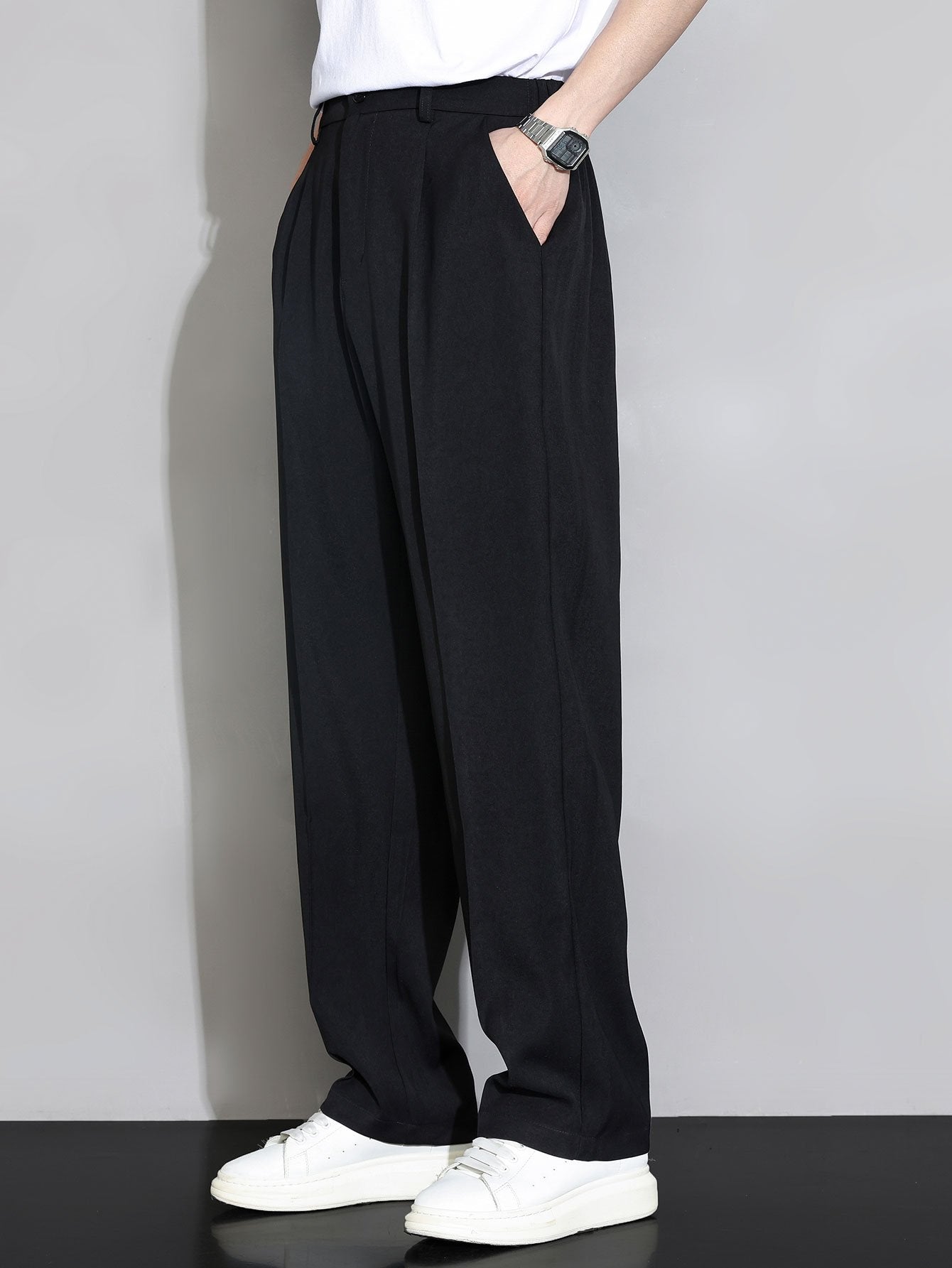 Pantalón recto relajado negro con pliegues en la cintura y pernera amplia.