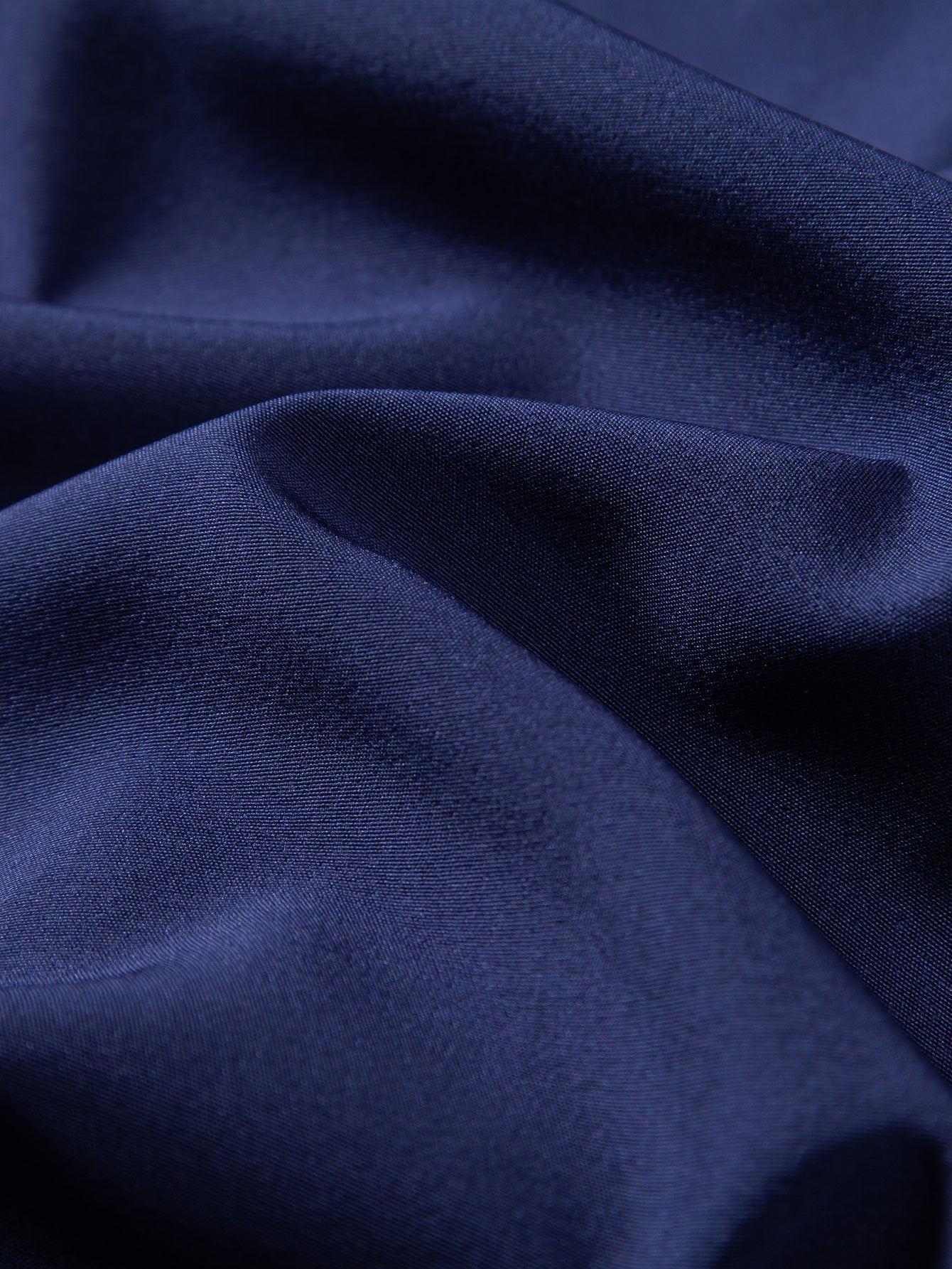 Tela de camisa azul marino lisa con caída suave y textura fina