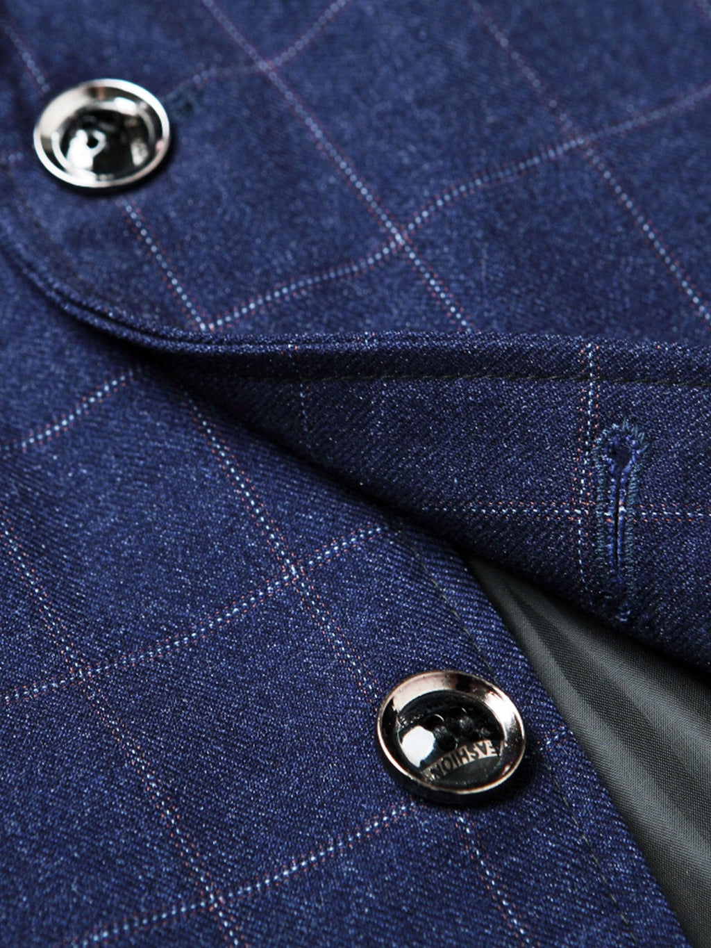 Detalle del blazer azul marino: botón metálico y solapa con cuadros
