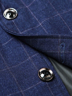 Detalle del blazer azul marino: botón metálico y solapa con cuadros