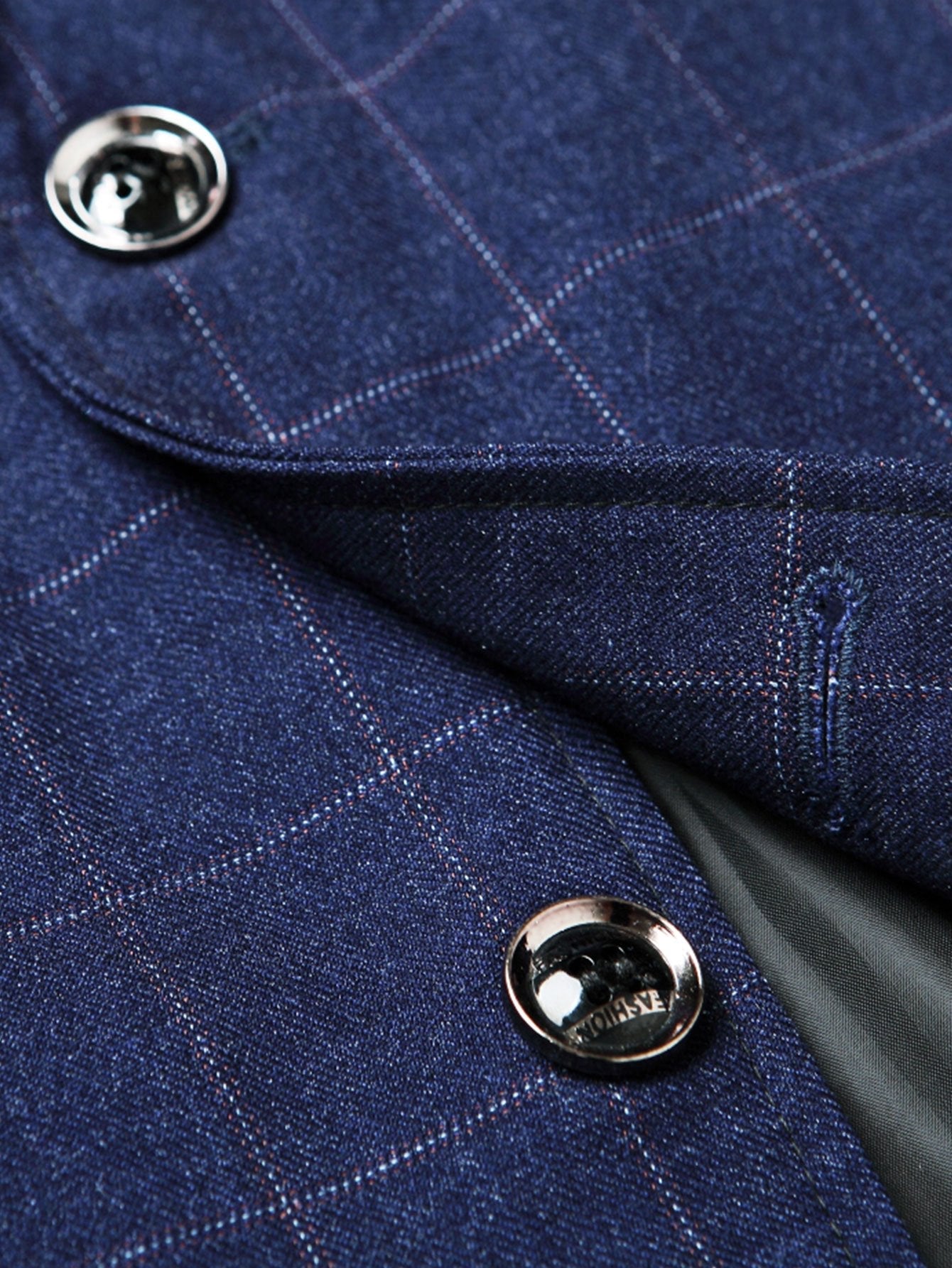 Detalle del blazer azul marino: botón metálico y solapa con cuadros