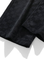 Pierna del pantalón recto con tejido cuadriculado negro y costuras visibles
