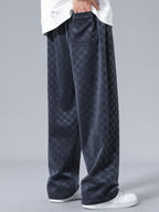 Pantalón recto oscuro con patrón damero, bolsillos traseros y bajo amplio.