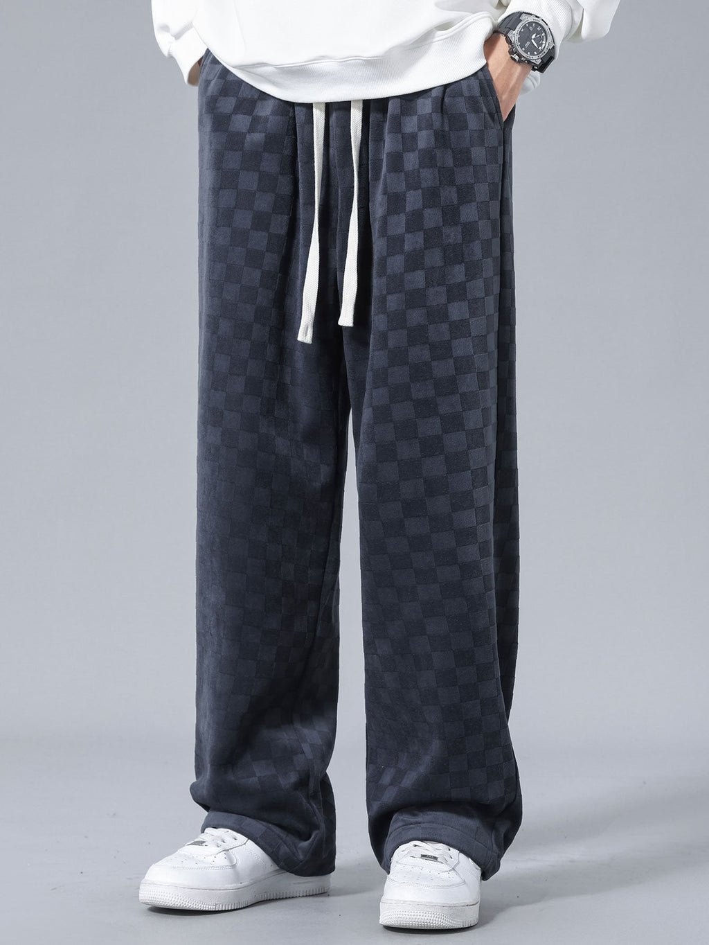 Pantalón recto oscuro con patrón damero, tiro holgado y cordón en cintura.
