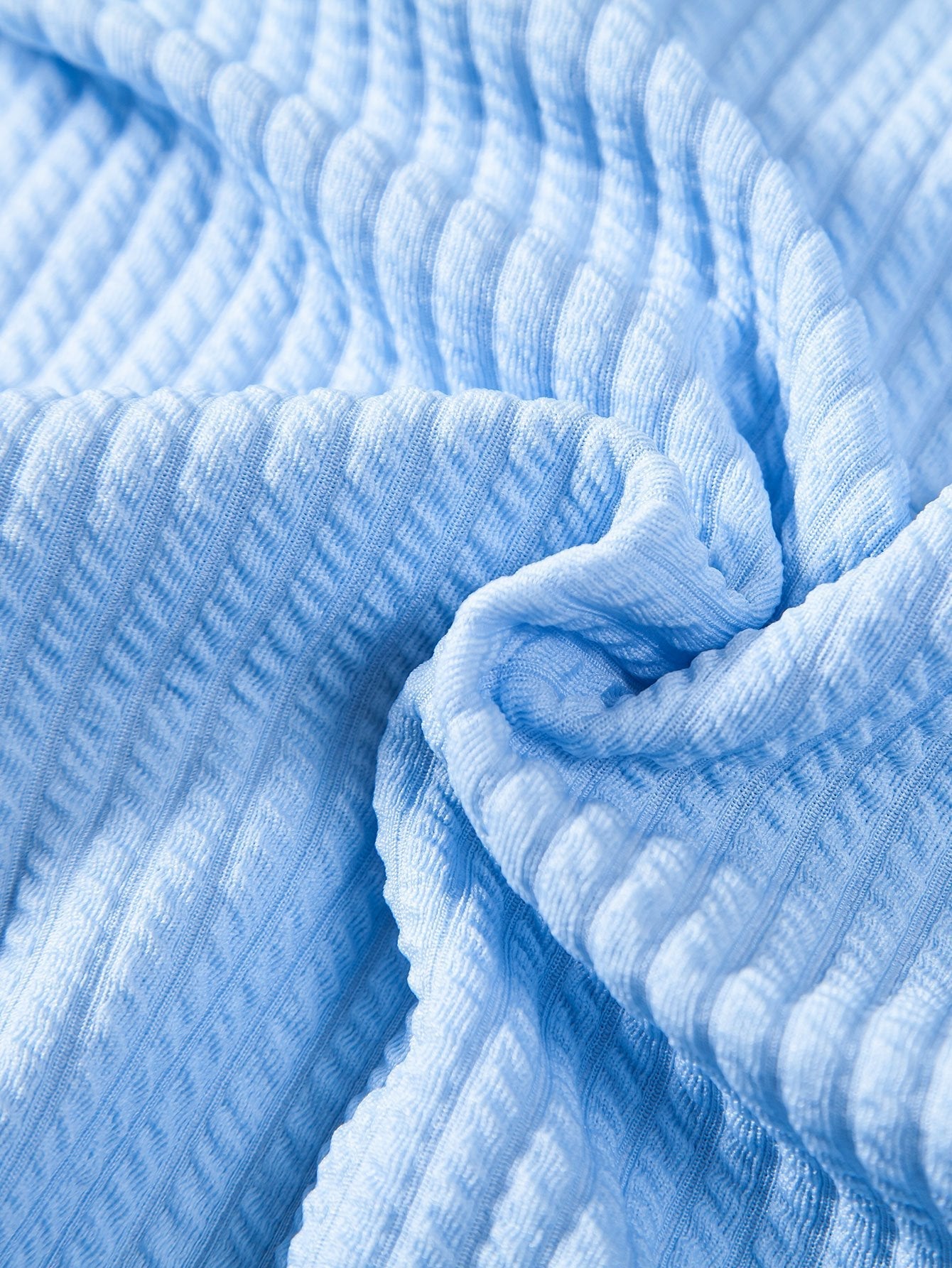 Tela acanalada azul claro con textura marcada y pliegues