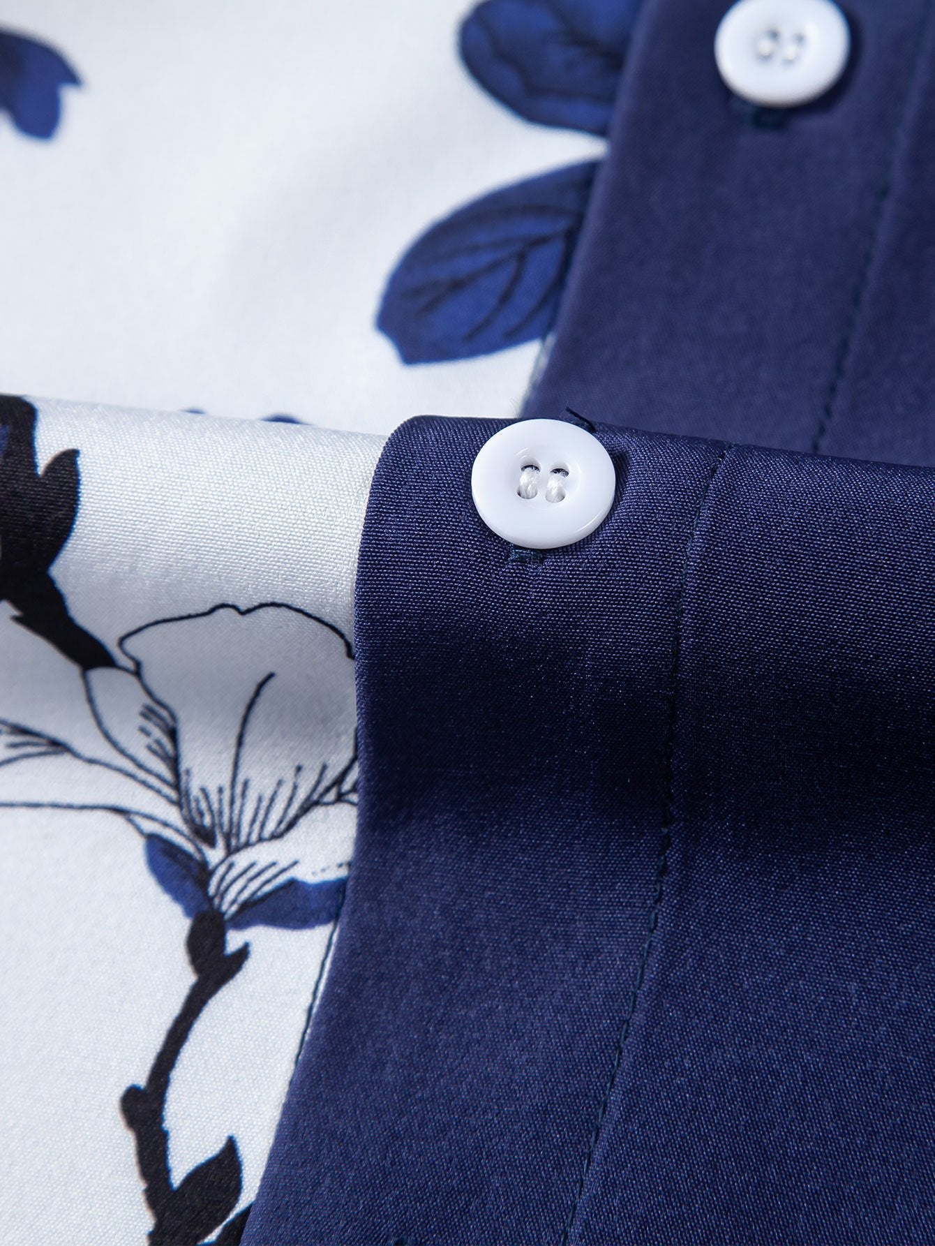 Detalle de botones blancos en camisa azul marino con estampado floral